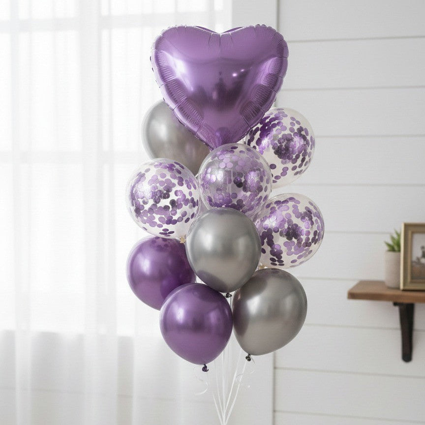 Bouquet of purple, silver, and clear balloons against a white wall.